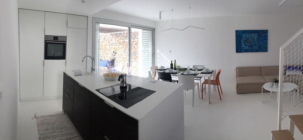 Cuisine moderne avec coin repas et accès à la terrasse
