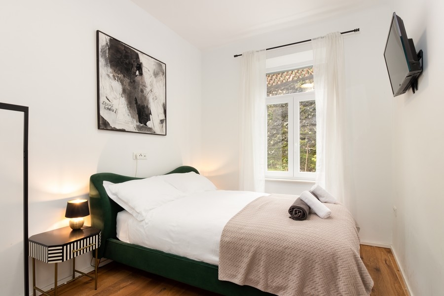 Chambre avec lit vert et table de chevet