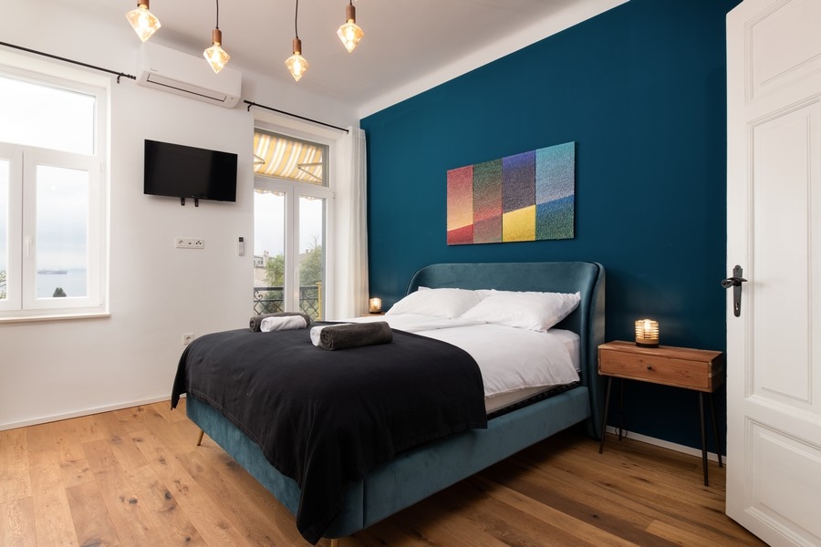 Chambre avec vue mer et mur bleu foncé