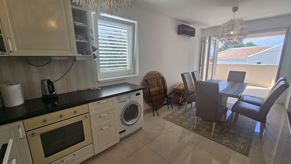 Cuisine et coin repas avec accès au balcon
