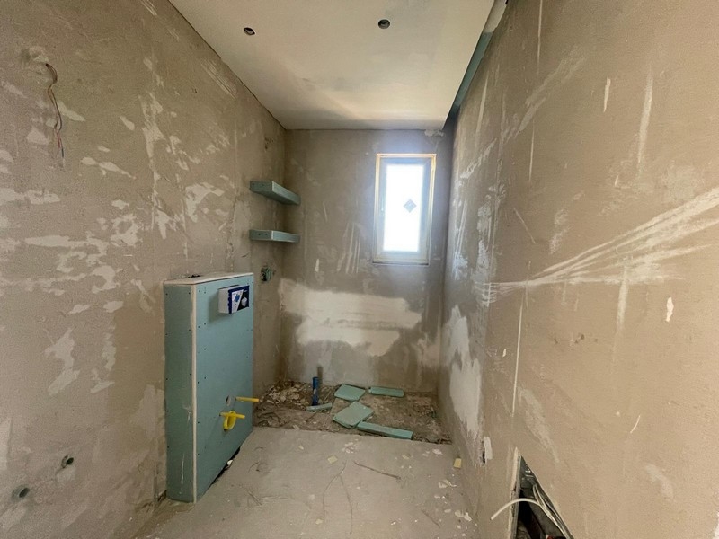 Salle de bains en gros œuvre avec fenêtre