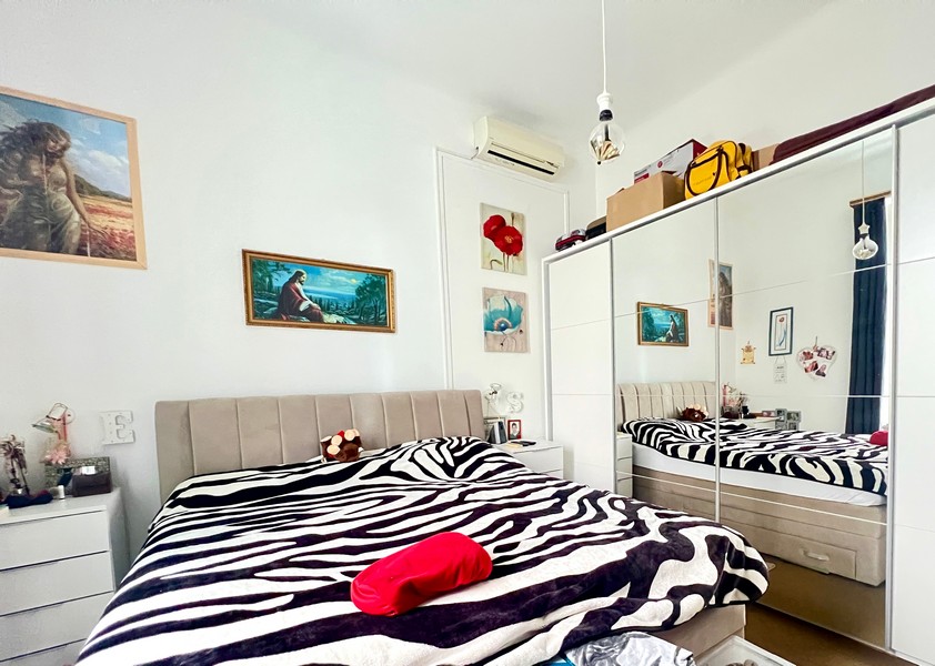 Chambre avec couverture zébrée et armoire à miroir