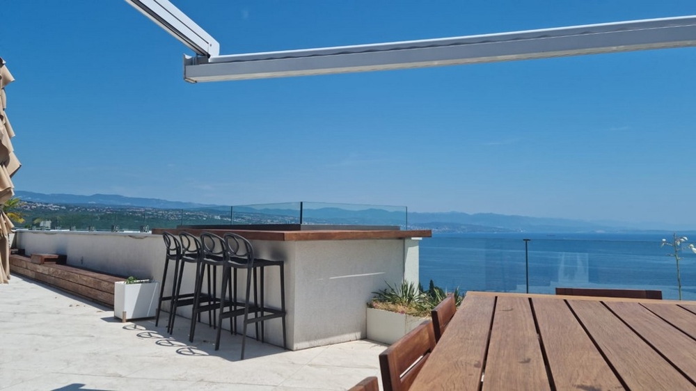 Toit-terrasse avec comptoir et tabourets de bar au-dessus de la baie