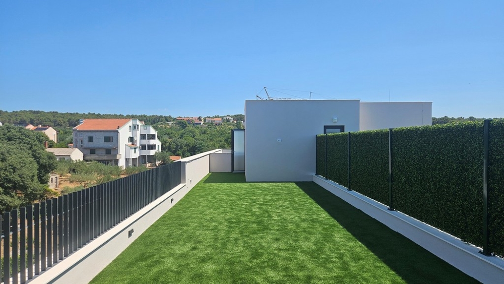 Toit-terrasse avec gazon synthétique et vue sur la verdure