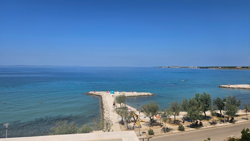Vue par-dessus la plage et la jetée sur l'eau turquoise