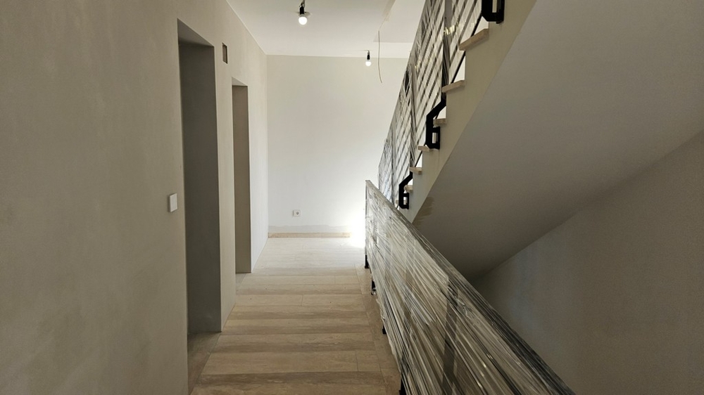 Vue arrière de l'immeuble neuf moderne avec places de stationnement et vue mer