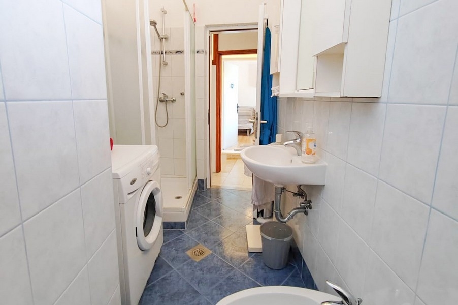 Salle de bains avec douche et lave-linge