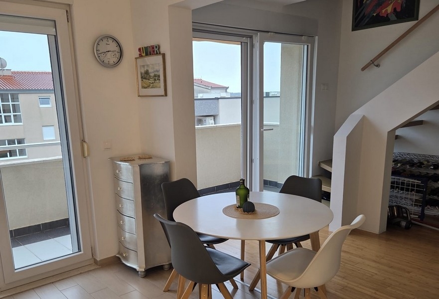 Coin repas avec table ronde et accès au balcon
