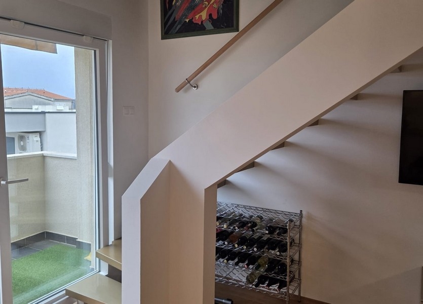 Escalier avec porte vitrée et accès au balcon