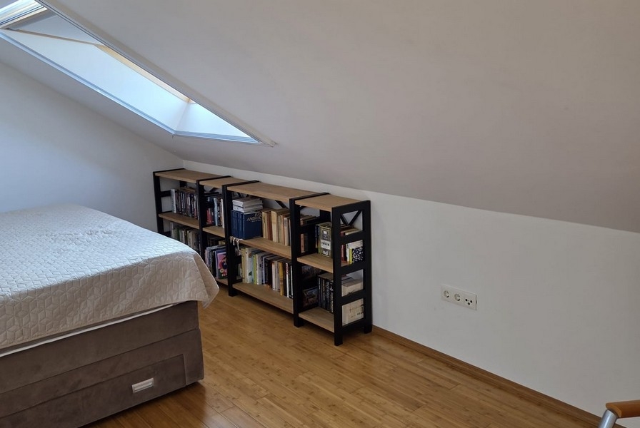 Chambre avec toit en pente et bibliothèques