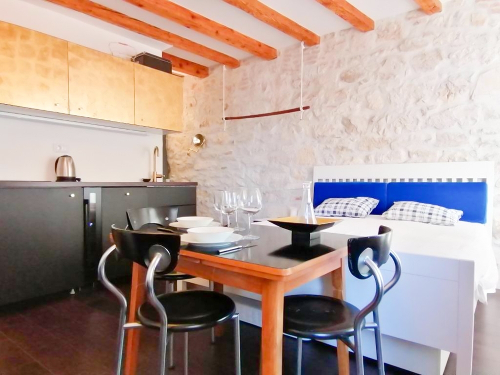 Espace repas, cuisine et lit.