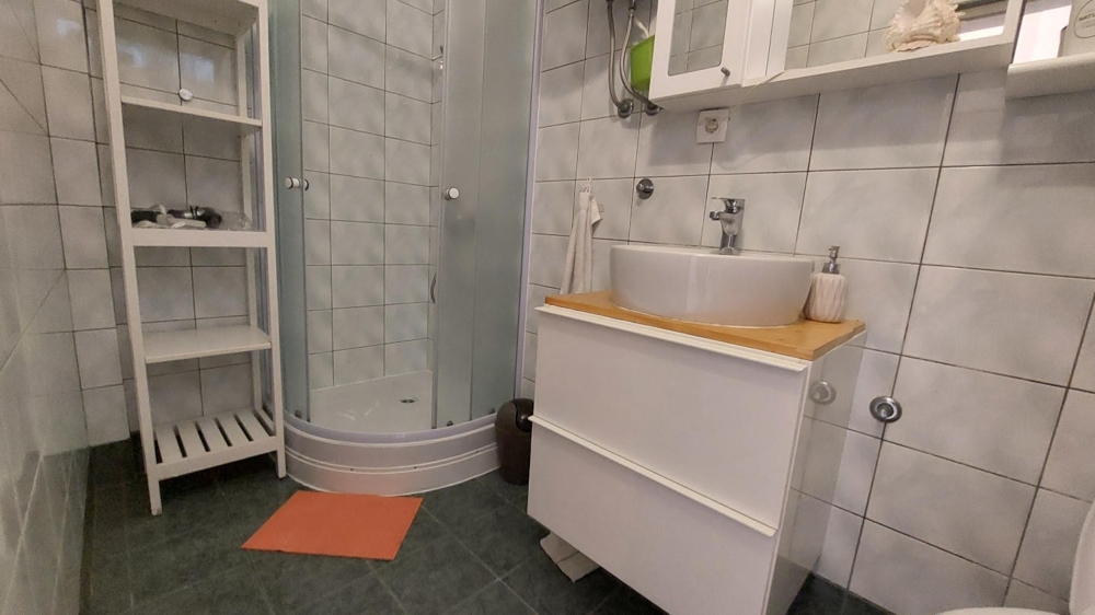 Salle de bains avec douche, lavabo et carrelage
