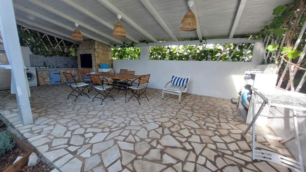 Cuisine d'été couverte avec table à manger et coin grill