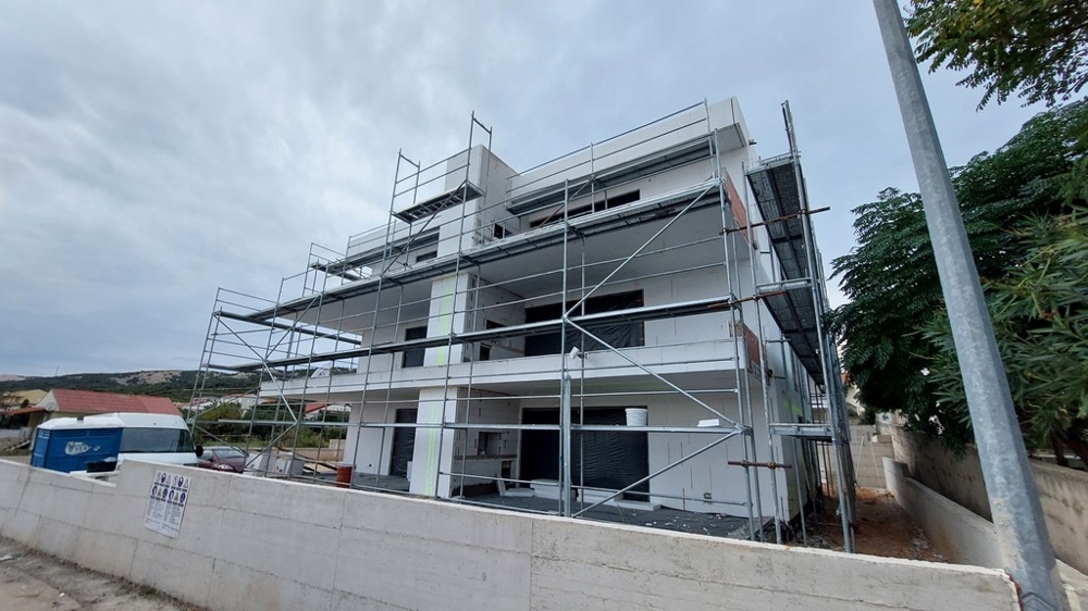 Immeuble neuf avec échafaudage sous un ciel nuageux