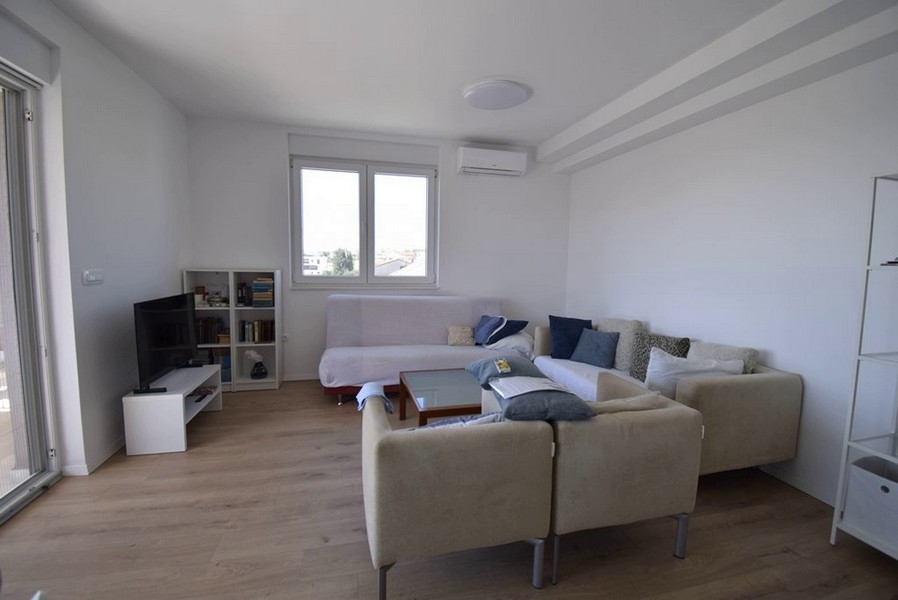 Séjour avec coin salon, TV et façade vitrée