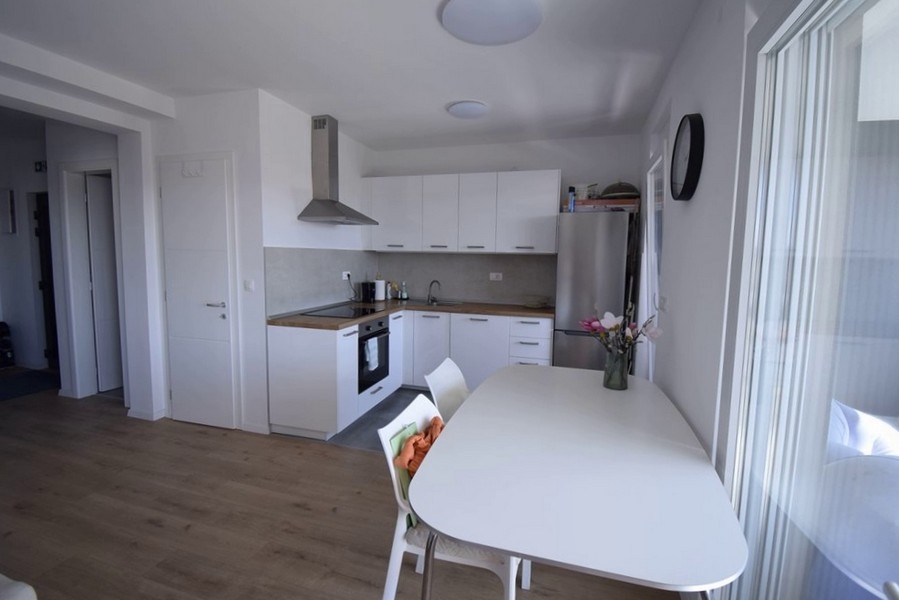Cuisine avec coin repas et accès au balcon