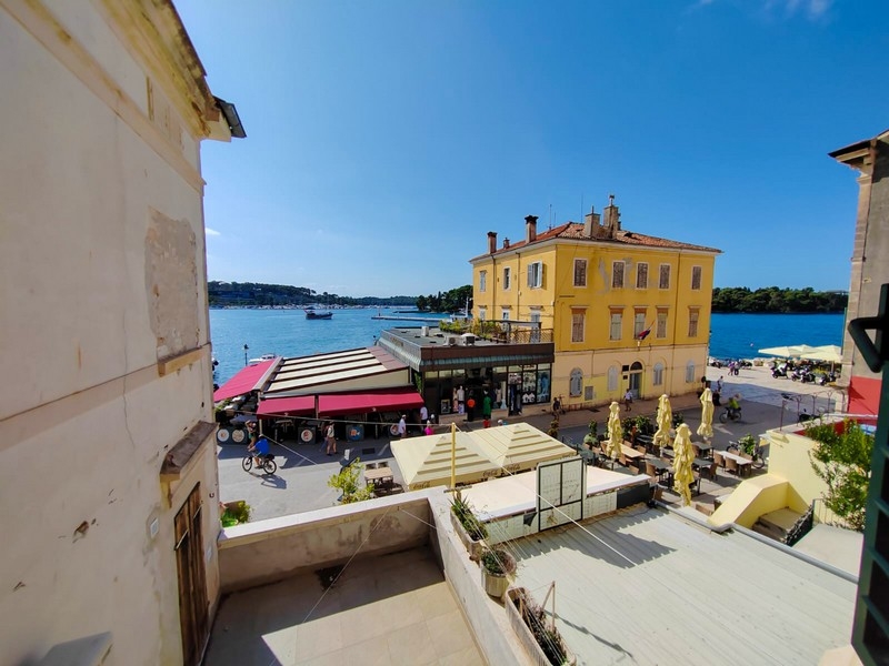 Vue sur la promenade du port avec palais jaune et restaurants