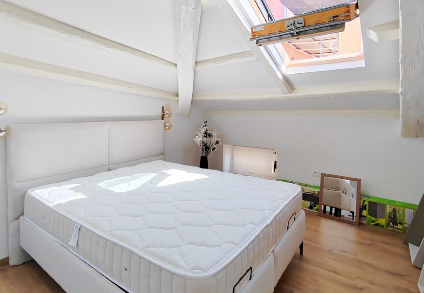 Chambre sous les combles avec lit double et fenêtre de toit