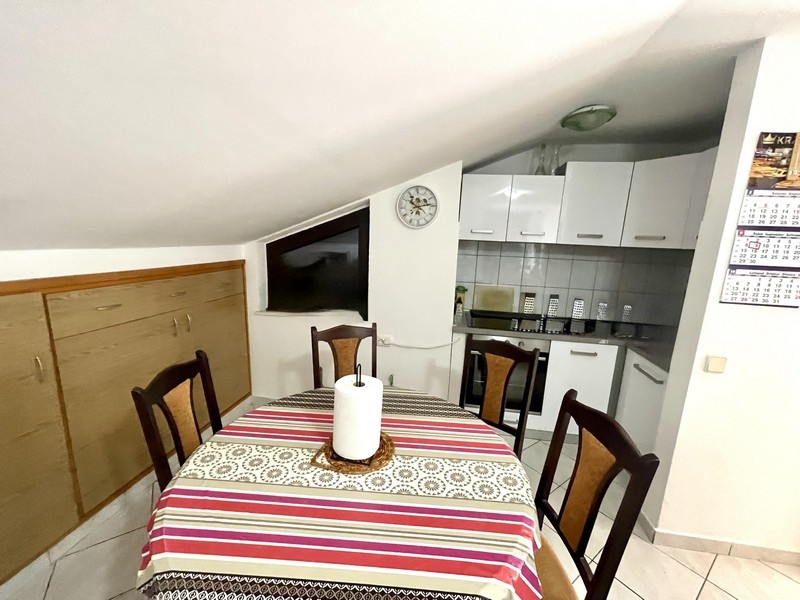 Coin repas avec table et chaises à côté de la cuisine