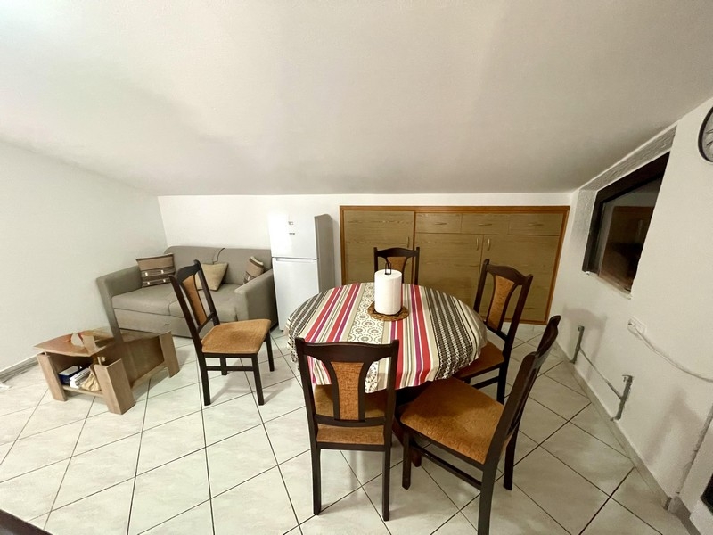 Séjour et coin repas avec canapé, réfrigérateur et table