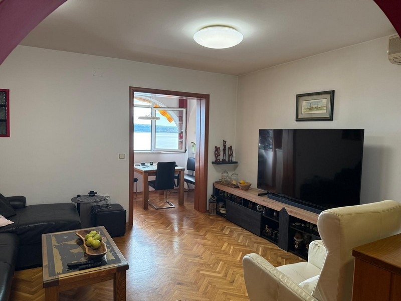 Salon avec télévision et vue mer à l'arrière-plan