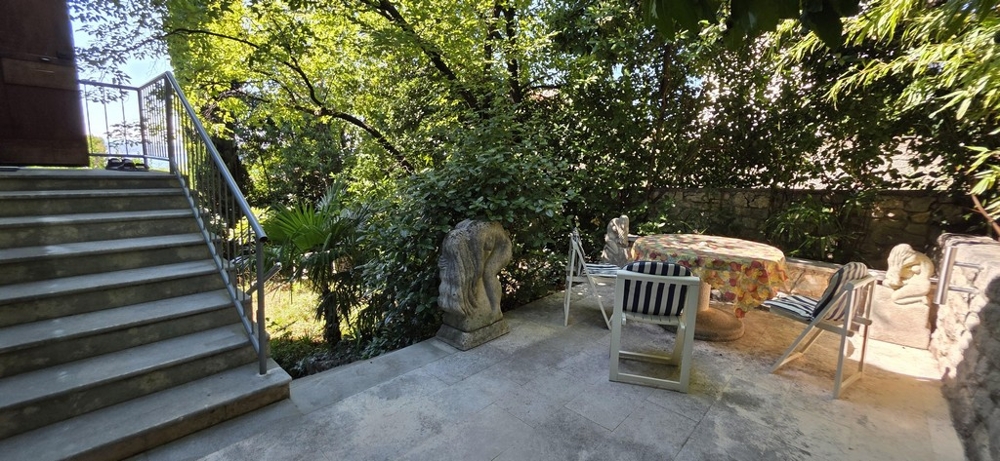 Terrasse avec coin salon et escalier vers le jardin