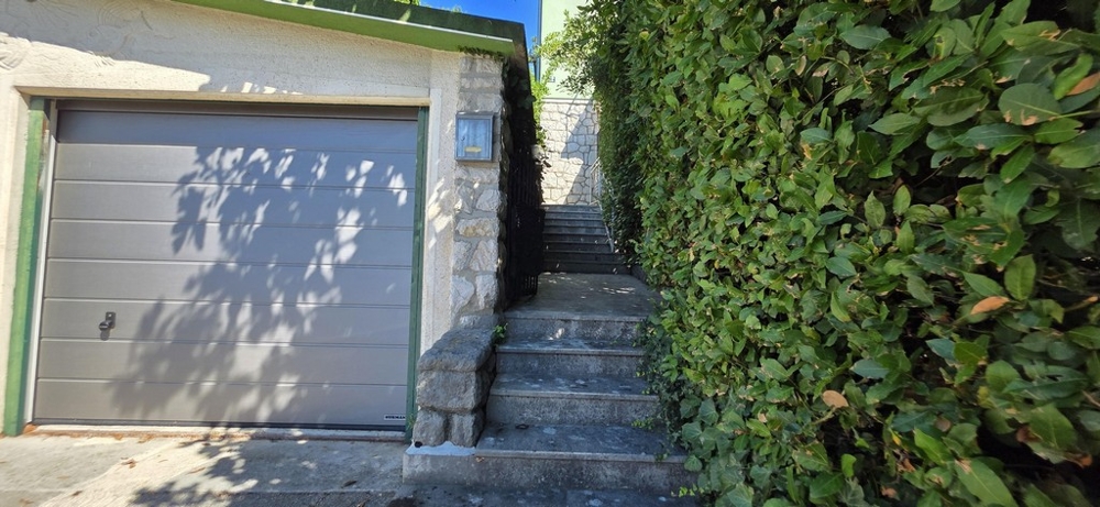 Garage avec escalier montant vers la maison