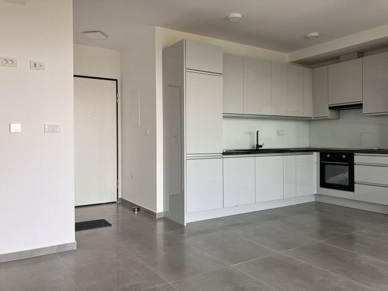 Cuisine ouverte avec cuisine équipée blanche et carrelage