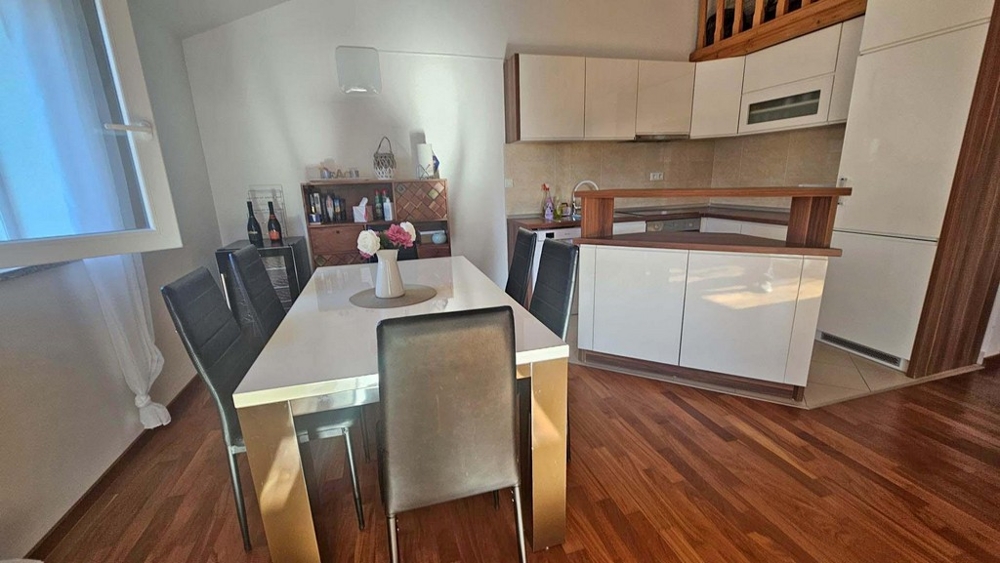 Coin repas avec table et accès à la cuisine moderne