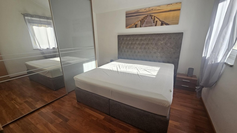 Chambre avec lit double et grande armoire à miroir