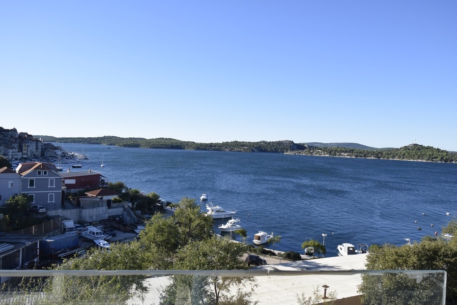 Vue du balcon par-dessus les bateaux et la baie sur le versant boisé