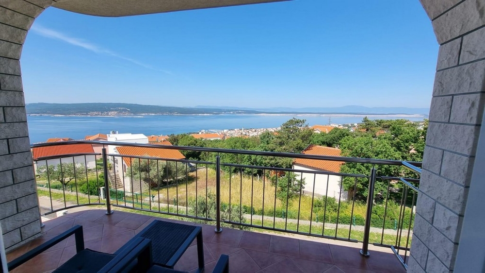 Loggia avec arc en plein cintre et vue par-dessus les toits sur la baie