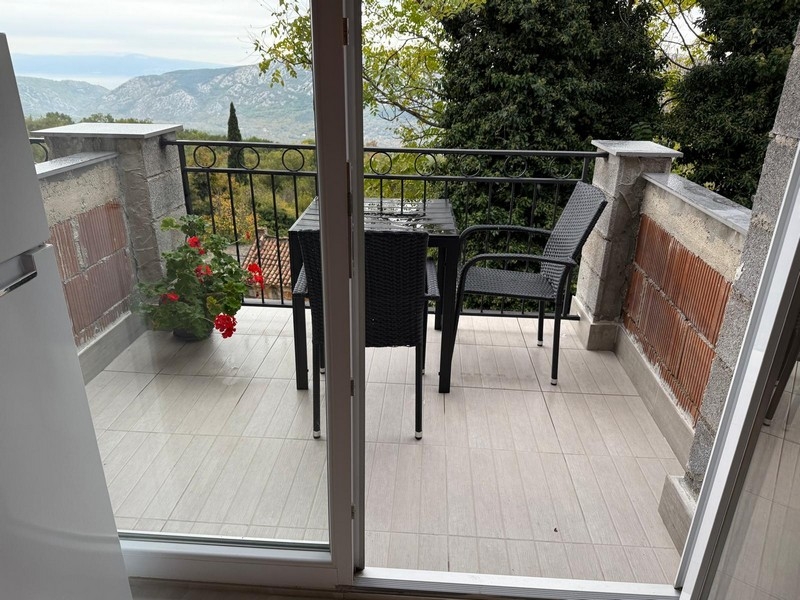 Balcon avec table et géraniums devant le panorama des montagnes