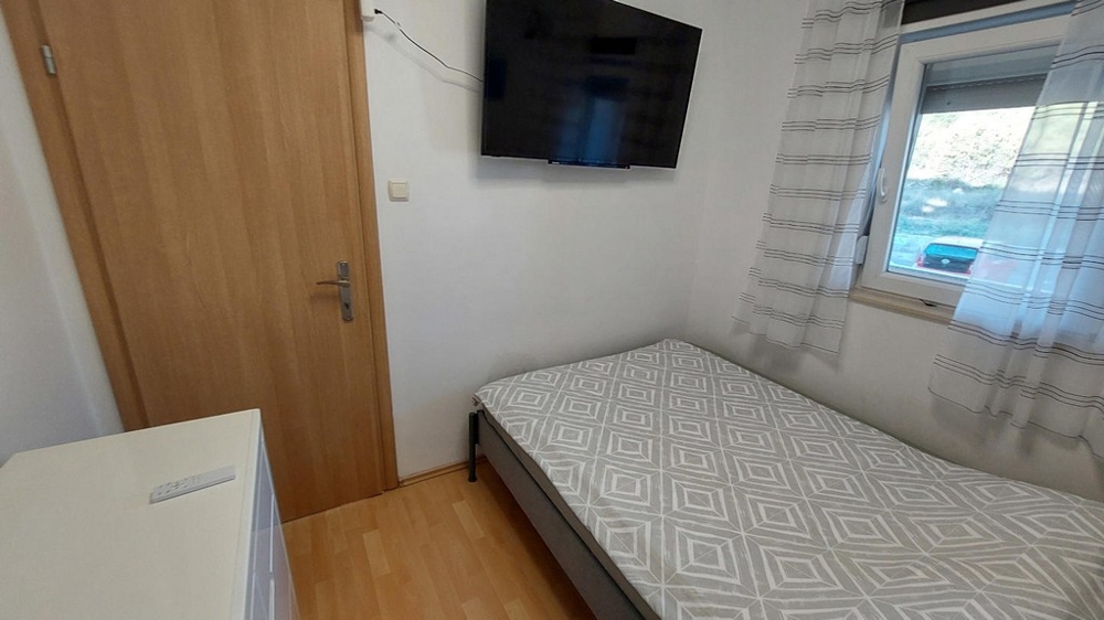 Deuxième chambre avec lit simple et TV
