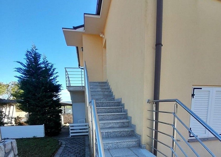 Escalier extérieur menant à l'entrée de l'appartement avec rampe en inox