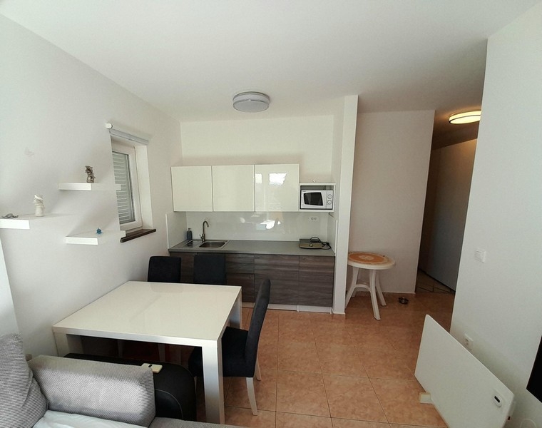 Séjour et cuisine lumineux avec carrelage et accès au couloir