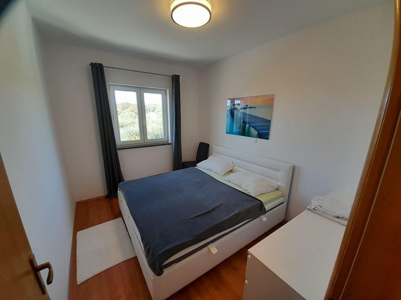 Chambre avec lit double, fenêtre et tableau mural