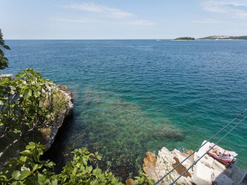 Côte rocheuse avec eau claire et plateforme de baignade