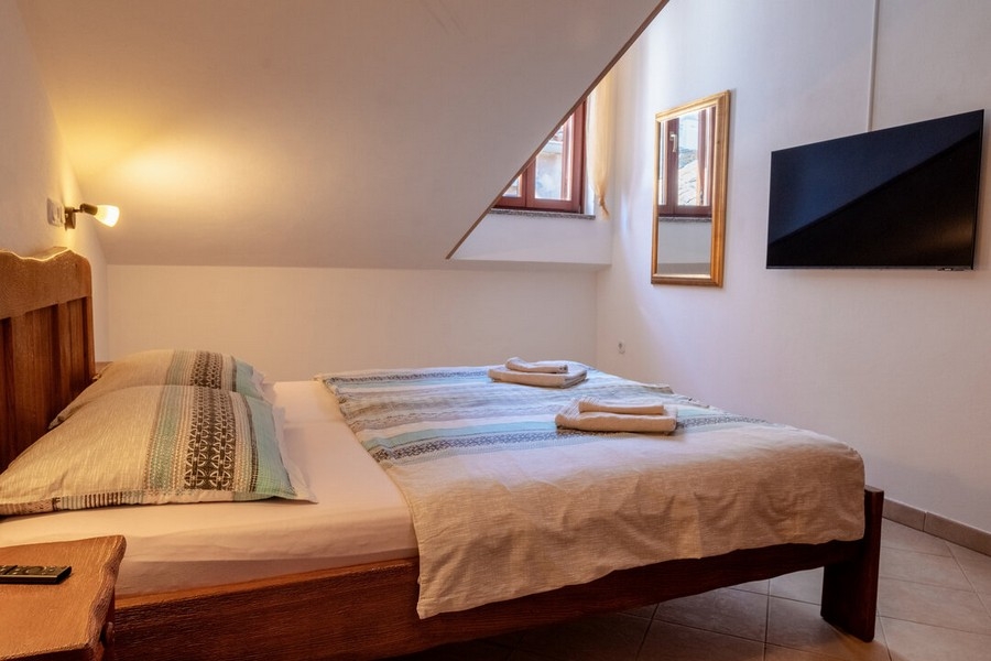 Chambre avec lit double et TV murale