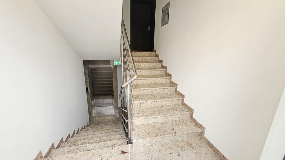 Cage d'escalier avec ascenseur et marches en marbre