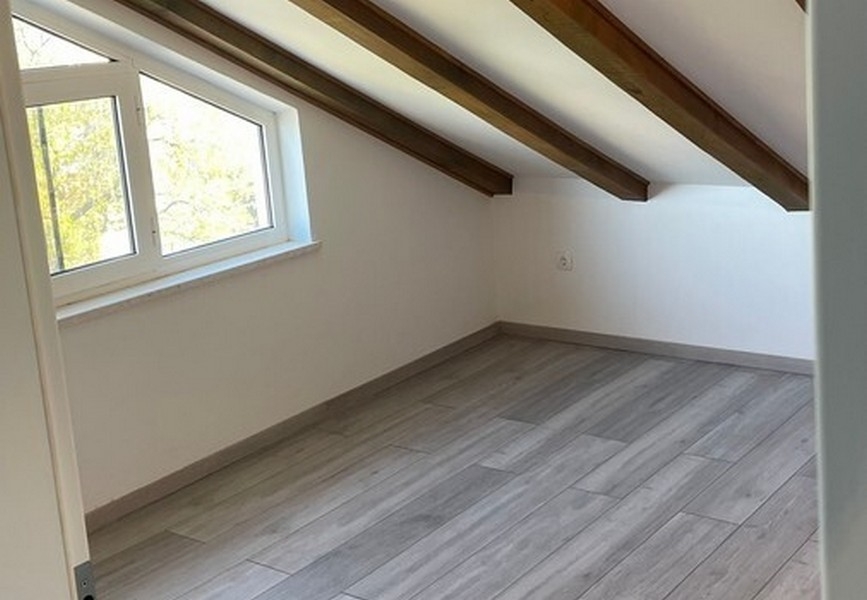 Pièce sous les combles avec poutres de toit apparentes
