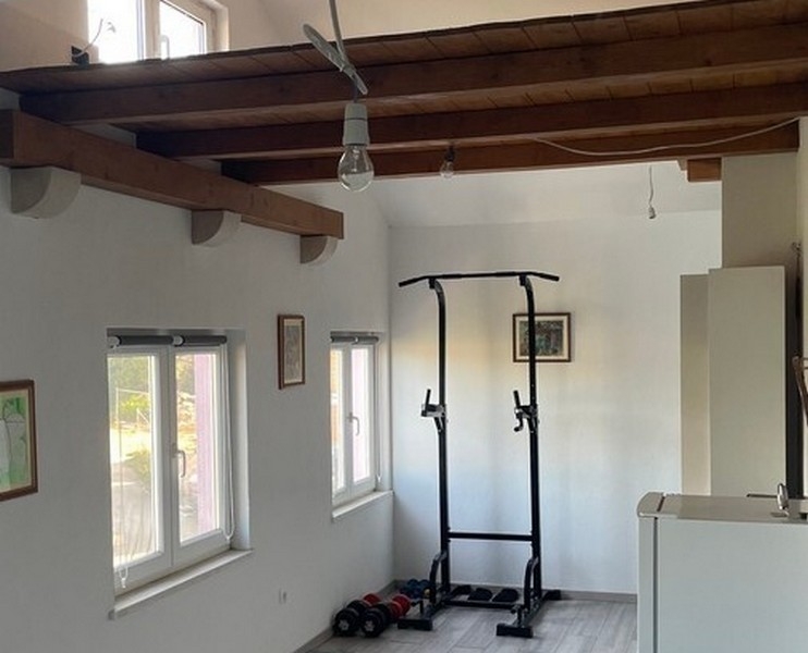 Espace fitness sous les poutres en bois dans le séjour