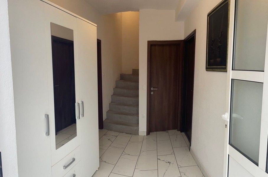 Entrée avec escalier et meubles encastrés blancs