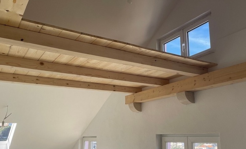 Poutres en bois et niveau en galerie sous le toit