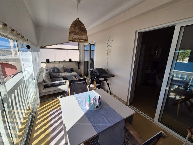 Terrasse vitrée avec coin salon et vue mer
