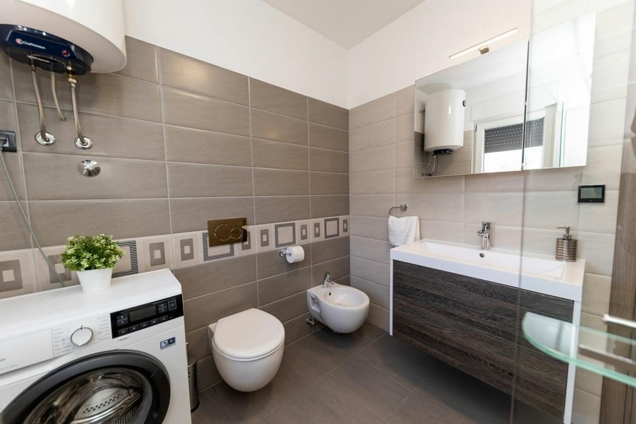 Salle de bains avec lave-linge et douche