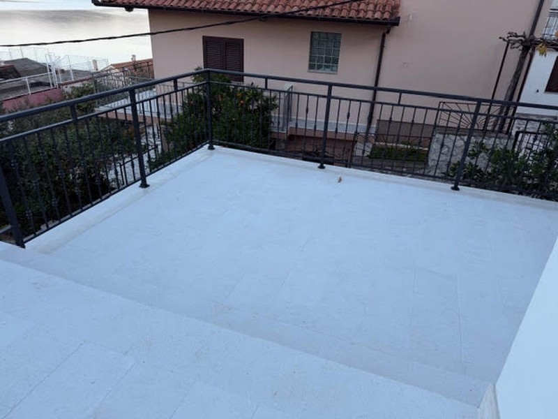 Terrasse avec garde-corps et vue sur la maison voisine