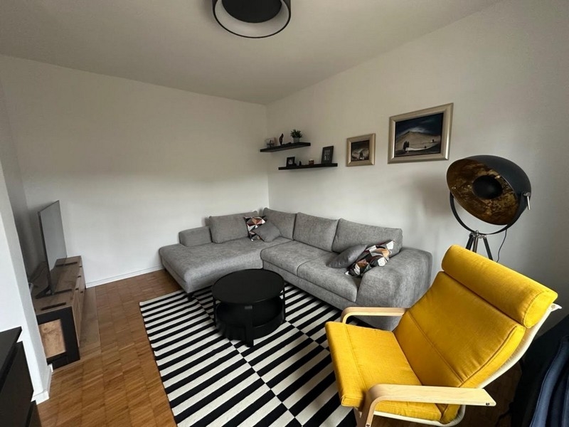 Séjour avec canapé d'angle gris et fauteuil jaune