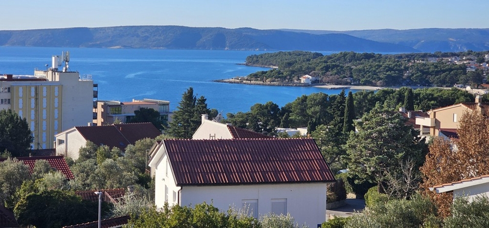 Vue par-dessus les toits et les pins sur la vaste baie