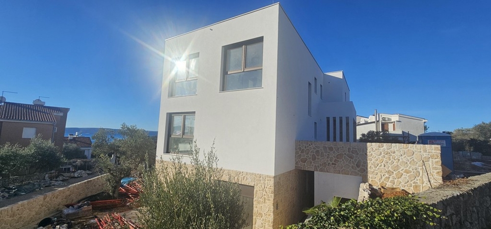 Maison blanche avec soubassement en pierre naturelle à contre-jour